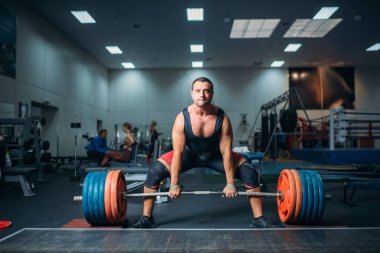 Erkek halterci ağır halter, deadlift, spor salonu iç zemin üzerine çekmek hazırlar. Halter egzersiz spor ya da fitness club, vücut geliştirme