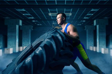 Gücü egzersiz ile kamyon lastik spor salonunda, crossfit egzersiz yaparak güçlü erkek atlet. Çapraz uygun eğitim spor kulübü