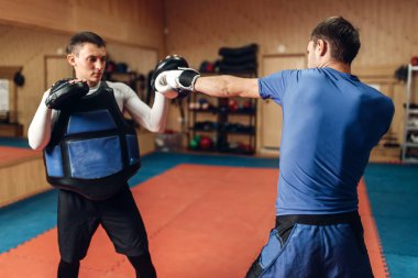 El yumruk bir kişisel antrenör yastıkları, spor olarak çalışma ile pratik eldiven erkek kick boks şampiyonu. Boksör eğitim, kickboks uygulama