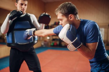 El yumruk bir kişisel antrenör yastıkları, spor olarak çalışma ile pratik eldiven erkek kick boks şampiyonu. Boksör eğitim, kickboks uygulama