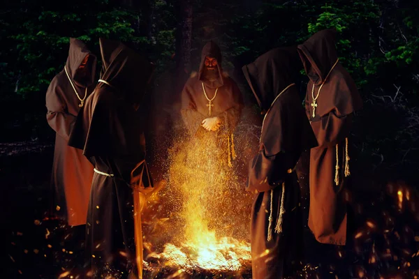 中世纪的僧人在夜间祈祷 祈祷反对大火 秘密仪式 神秘的修士在黑暗的斗篷 神秘与灵性 — 图库照片