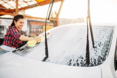 Oto yıkama, cennet süreci kendi kendine kadınlarda. Açık araç yaz gününde yıkama. Sünger ile kadın kişi Otomobil ön cam temizler