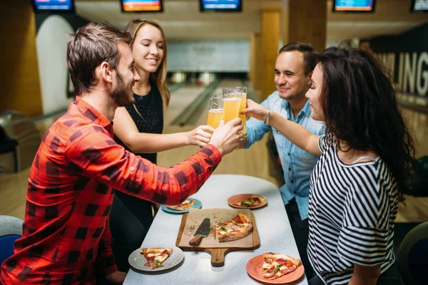 Friends drinks juice and eat pizza in bowling club, active leisure, healthy lifestyle, bowling game
