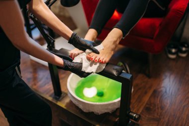 Pedikür ustası siyah eldiven kozmetik prosedür, güzellik salonda kadın müşteri yapıyor. Profesyonel tırnak bakımı