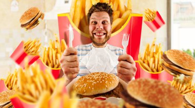 Fast food kavramı, insan ve patates kızartması ile hamburger. Bıçak ve çatal ile erkek deli yemeye hazırlar