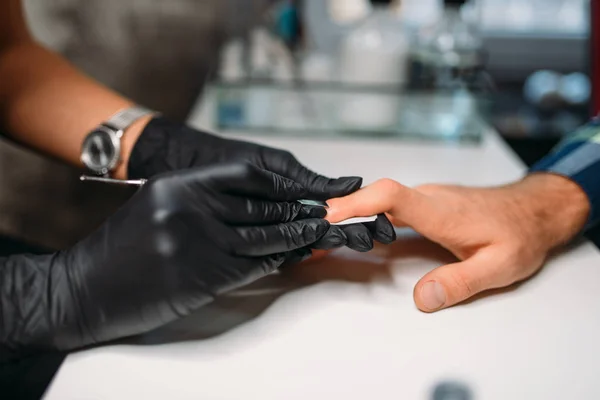女主人在黑色手套抛光指甲男性客户 顶视图 男性修指甲在沙龙 修管师做手护理程序 — 图库照片