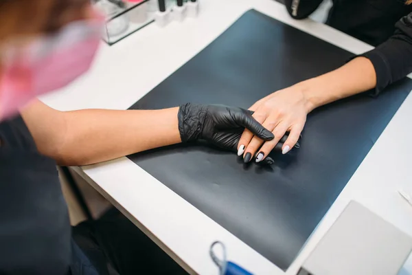 美容师在手套举行抛光机和清洁旧清漆从指甲的女性客户 顶视图 美甲在美容院 修管师做手照顾整容程序 — 图库照片