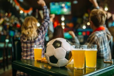 Top ve bira spor bar, futbol taraftarları arka plan üzerinde tablo. Oyun kavramını izlerken Tv yayını