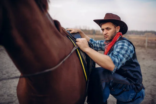 穿着牛仔裤和皮夹克的残酷牛仔骑着马爬上了西部的德州牧场 复古男性人与马 狂放的西部 — 图库照片