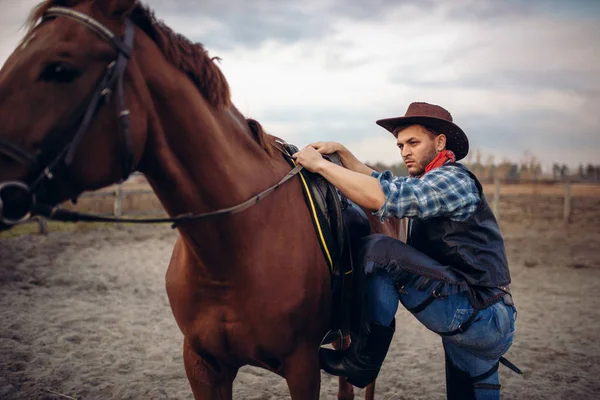 穿着牛仔裤和皮夹克的残酷牛仔骑着马爬上了西部的德州牧场 复古男性人与马 狂放的西部 — 图库照片
