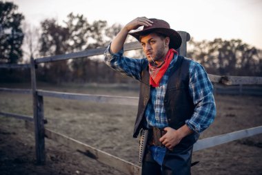 Deri ceket ve şapka genç kovboy at corral, Batı karşı teşkil etmektedir. Vintage erkek kişi, vahşi batı tarzı retro Amerikan moda