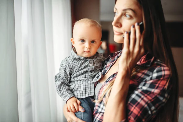Молодая Мать Держит Ребенка Руках Разговаривает Телефону Помещении Мама Сын — стоковое фото