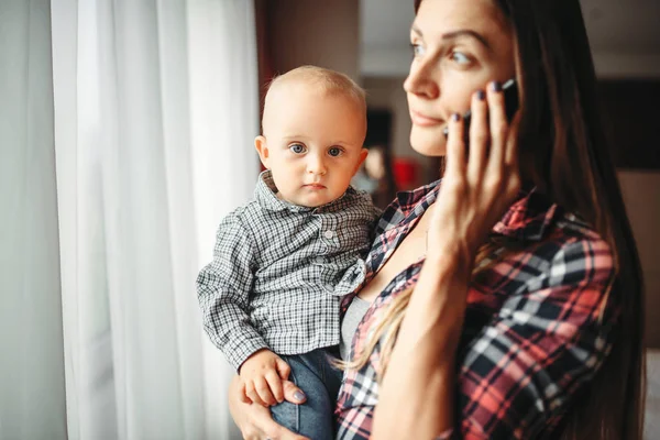 Junge Mutter Hält Ein Baby Auf Dem Arm Und Telefoniert — Stockfoto