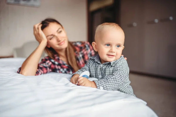 Tired Mother Looks Her Little Child Playing Bed Motherhood Problems — Stock Photo, Image