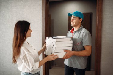 Kadın müşteri sipariş pizza servis elemanı, hizmet teslim hızlı alır. Pizzacı taşıma karton kutularda ve kapıdaki kadın kurye