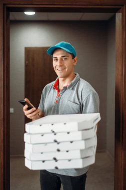 Pizza servis elemanı müşteri hizmeti sunan, t-shirt ve şapka çağrıları. Pizzacı gelen kurye karton paketler ve telefon tutar