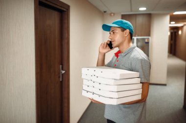 Kapıda pizza teslimi adam hizmet teslim müşteri için çağırır. Pizzacı gelen kurye karton kutularda ve konuşma telefonla kapalı tutar