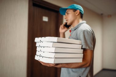 Kapıda pizza teslimi adam hizmet teslim müşteri için çağırır. Pizzacı gelen kurye karton kutularda ve konuşma telefonla kapalı tutar