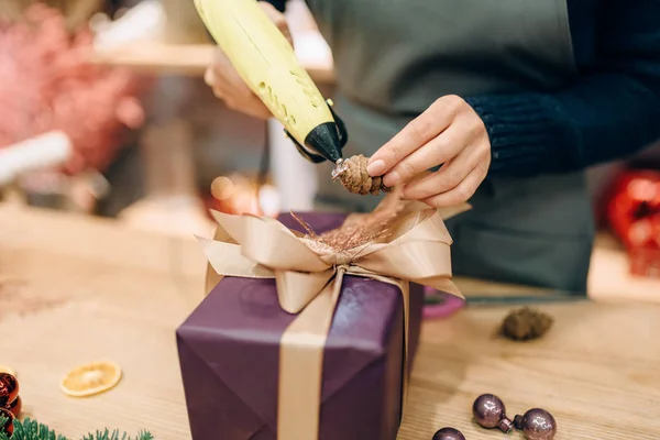 Vrouwelijke Verkoper Siert Geschenkdoos Met Spar Kegel Handgemaakte Verpakking Decoratie — Stockfoto