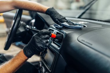 Araba iç carwash hizmetine otomatik detaylandırma. İşçi eldiven fırça ile salon temizler