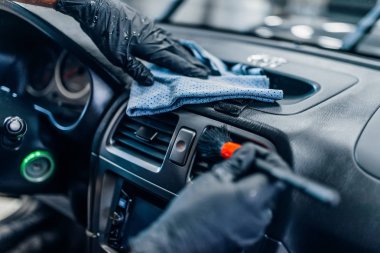 Araba iç carwash hizmetine otomatik detaylandırma. İşçi eldiven fırça ile salon temizler