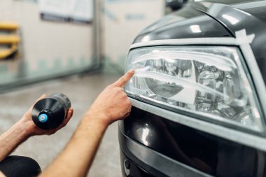 Otomatik araba farlar carwash hizmet detaylandırma. Adam parlatma yapıştırmak smear