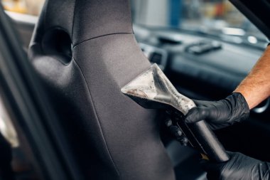 Oto koltuğu elektrikli süpürge ile profesyonel Kuru Temizleme. Cennet Servisi, Erkek işçi toz kaldırır.