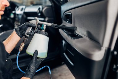Cennet Servisi, özel sprey kullanarak eldiven erkek işçi. Profesyonel Kuru Temizleme diye bir arabanın kapısını trim, araç iç hijyen