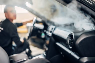 Cennet Servisi, eldiven erkek işçi buharlı temizleyici ile salon temizler. Araba iç profesyonel Kuru Temizleme