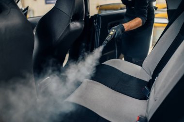 Cennet Servisi, eldiven erkek işçi buharlı temizleyici ile koltuk temizler. Araba iç profesyonel Kuru Temizleme