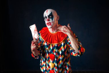 Et cleaver, sirk korku ile deli kanlı palyaço. Makyaj karnaval kılık, manyağı adamla