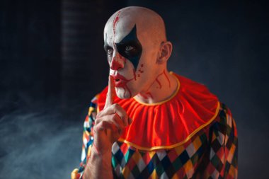 Deli kanlı palyaço portresi sessiz işaretleri, yüzü kan içinde gösteriyor. Makyaj içinde Halloween kılık, manyağı adamla 