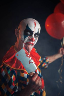 Korkunç lanet palyaço bıçak bıçak yalıyor. Makyaj içinde halloween kılık, manyağı adamla insan elini tutar