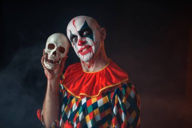 Kahrolası palyaço ile deli yüz insan kafatası, korkunç sır tutar. Makyaj karnaval kılık, deli manyak adam