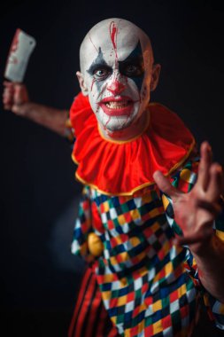Et cleaver, sirk korku ile deli kanlı palyaço. Karnaval kılık makyaj adamla