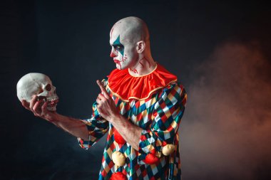 Deli kanlı palyaço insan kafatası kırmızı peruk, korku tutar. Makyaj karnaval kılık, manyağı adamla