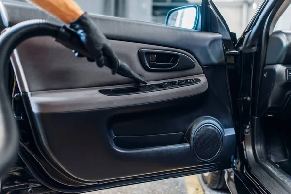 汽车内饰的汽车内饰自动细节上的洗车服务 工人在手套清洁门装饰与真空吸尘器 — 图库照片