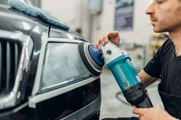 自動の洗車サービスに車のヘッドライトの詳細 人間研磨機での作業 — ストック写真