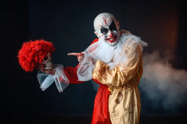 Сумасшедший Чертов Клоун Держит Человеческий Череп Красном Парике Ужас Человек — стоковое фото