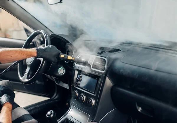 Carwash service, male worker in gloves cleans salon with steam cleaner. Professional dry cleaning of car interior — Stock Image Carwash Service Male Worker Gloves Cleans Salon Steam Cleaner Professional Royalty Free Stock Photos