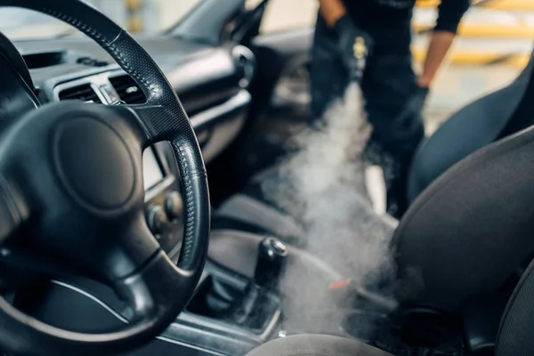 Professional dry cleaning of car salon with steam cleaner. Carwash service, vehicle salon hygiene, male worker removes dirt and dust — Stock Image Professional Dry Cleaning Car Salon Steam Cleaner Carwash Service Vehicle Stock Image