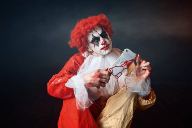 Korkunç lanet palyaço ile deli gözler onun bıçak arıyorum. Makyaj karnaval kılık, deli manyak adam