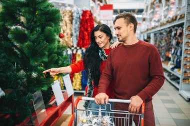 İki Noel ağacı süpermarkette satın alma. Tatil dekorasyon alışveriş, Aralık seçimi