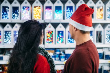 Genç çift Noel hediyeleri süpermarkette, Aile geleneği üzerinde görünüyor. Tatil dekorasyon alışveriş, Aralık seçimi