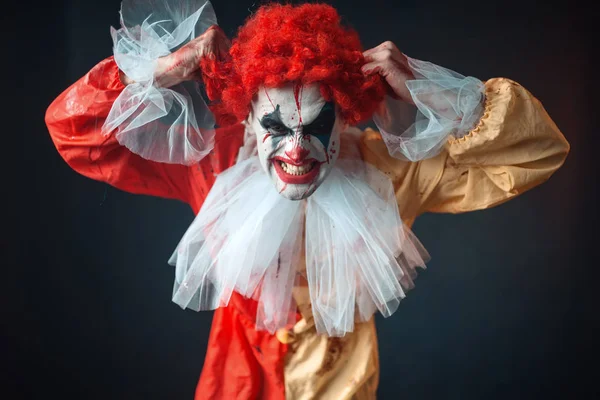 可怕的血腥小丑撕裂他的头发 在愤怒的混蛋 化妆在狂欢节服装的男人 疯狂的疯子 — 图库照片