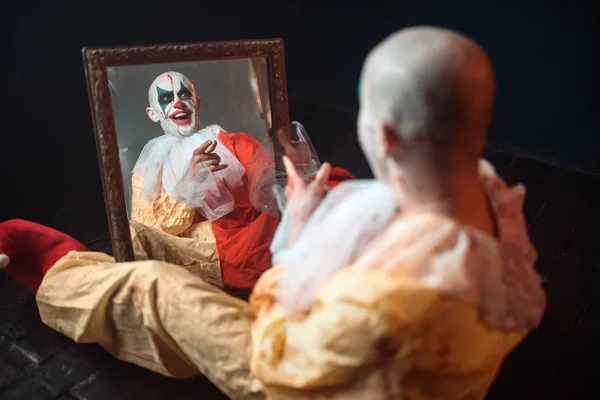 Porträtt Skrämmande Blodig Clown Med Galna Ögon Sitter Vid Spegeln — Stockfoto