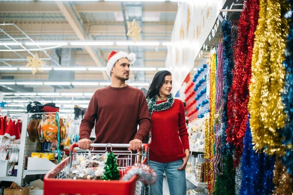 一对年轻夫妇在超市的节日装饰系 家族传统 十二月购物 — 图库照片