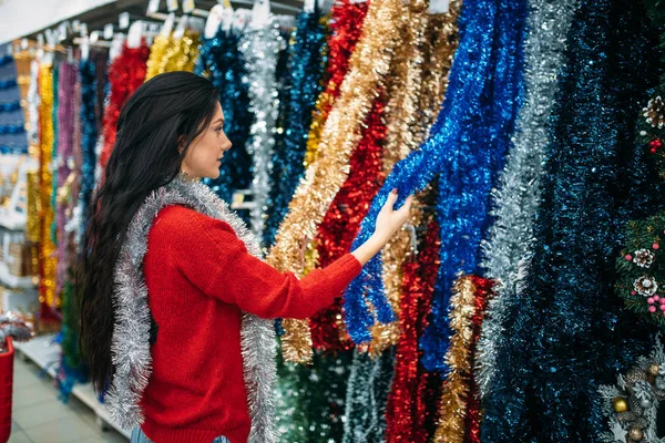 Молодая Женщина Выбирает Праздник Пушистые Гирлянды Покупка Рождественского Украшения Супермаркете — стоковое фото