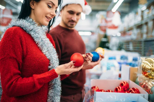 幸福的夫妇选择圣诞树球在超市 家庭传统 12月假日物品的购物 — 图库照片