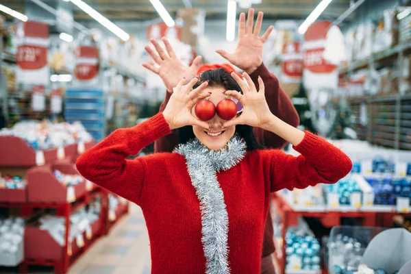 年轻的顽皮夫妇选择圣诞树球在商店 家庭传统 12月假日物品的购物 — 图库照片